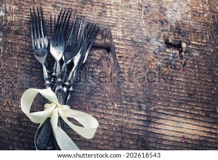 Vintage silverware on aged wooden background. Selective focus, horizontal.