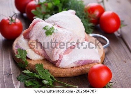 Fresh chicken meat on wooden board on table. Selective focus, horizontal.