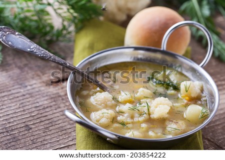 Soup with vegetables cauliflower, potato, onion in bowl on wooden background. Selective focus, horizontal.