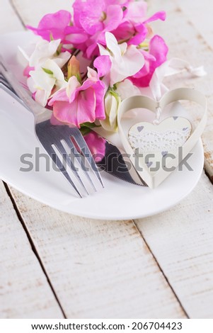 Romantic table setting. Sweet peas flowers on plate.  Selective focus.