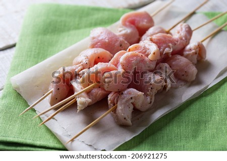 Marinated chicken meat on skewers ready to cook. Selective focus. Rustic style.