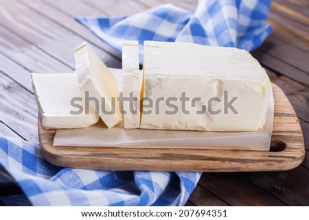 Fresh organic butter on board on wooden background. Rustic style. Bio/organic/natural ingredients. Healthy eating.