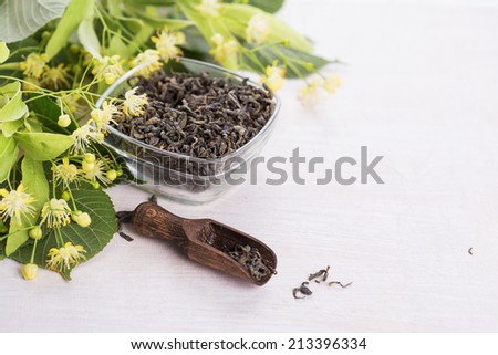 Dry green tea with linden on wooden background. Selective focus.