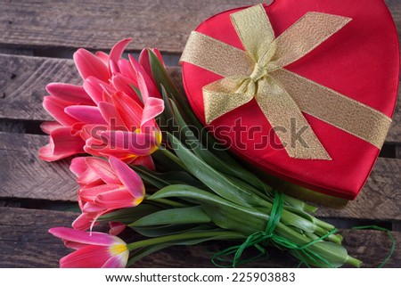 Postcard with fresh tulip flowers and heart on wooden background.  Selective focus. Spring, easter background.