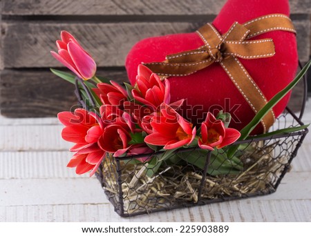 Postcard with fresh tulip flowers in bucket and heart on wooden background.  Selective focus. Spring, easter background.