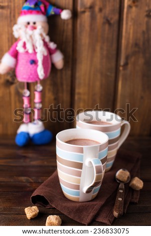 Christmas cocoa in mug  on wooden background. Selective focus is on the first  mug.