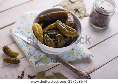Marinated organic cucumbers in bowl on white wooden table. Selective focus. Natural/organic/bio/healthy products.