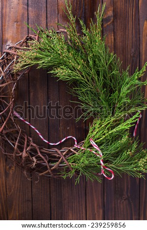 Decorative christmas composition - wreath and spruce  on wooden background. Selective focus.