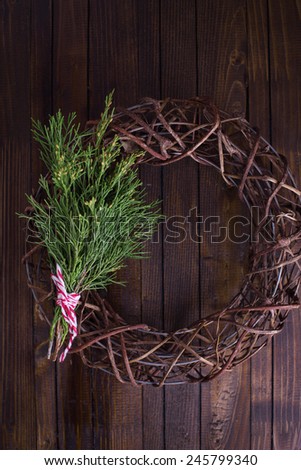 Decorative christmas composition - wreath and spruce  on wooden background. Selective focus.