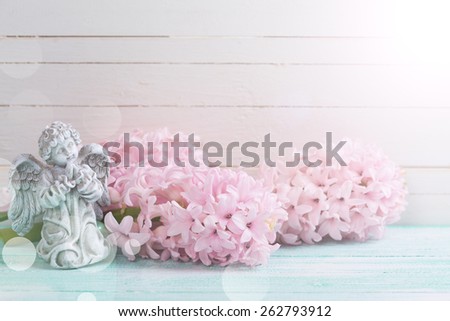 Postcard with fresh flowers hyacinths  and angel on turquoise painted wooden planks. Selective focus.