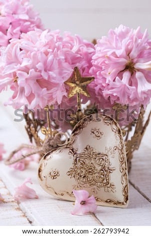Postcard with fresh flowers hyacinths and decorative heart on white  painted wooden planks. Selective focus.