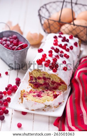 Fresh homemade cake with cranberry  on dish on white painted wooden planks. Selective focus.