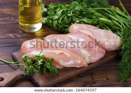 Fresh chicken meat on wooden board on table. Selective focus. Rustic style.