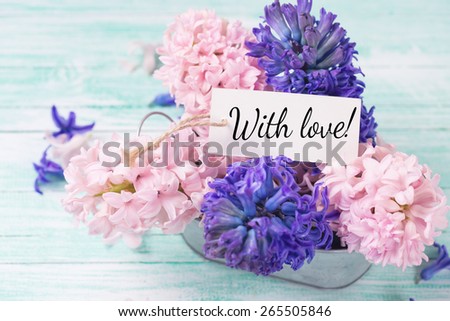 Postcard with fresh flowers hyacinths in bowl on turquoise painted wooden planks. Selective focus.