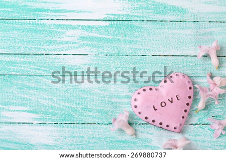 Postcard with little flowers hyacinths  and decorative heart on turquoise painted wooden planks. Selective focus. Place for text.