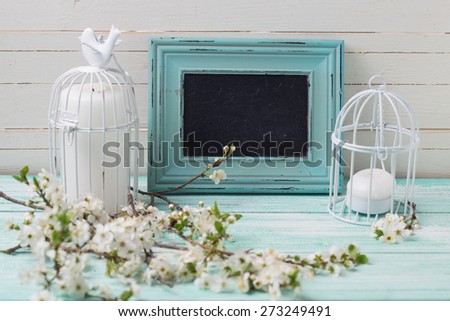 Postcard with white  branches  and candles  and empty blackboard on turquoise painted wooden planks against white wall. Selective focus is on blackboard.  Place for text. Toned image.