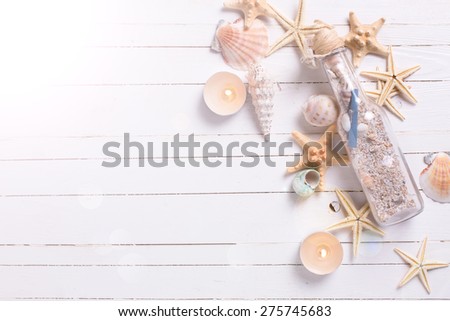Marine items and candles  on  white painted wooden background in ray of light . Sea objects on white wooden planks. Selective focus. Place for text.