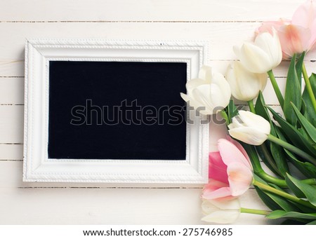 Postcard with fresh white and pink flowers and empty blackboard for your text on white painted planks. Selective focus. Toned image.