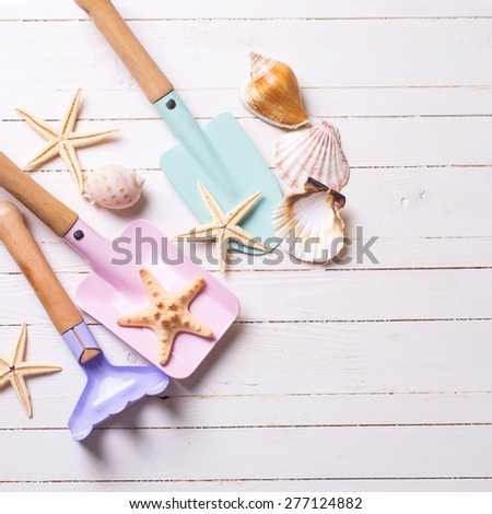 Tools for kids for playing in sand and sea object on white  painted wooden background. Place for text.  Square image.