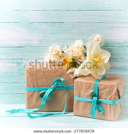 Festive present boxes  and flowers  on turquoise painted wooden background. Place for text. Selective focus. Square image.