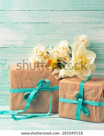 Festive present boxes  and flowers  on turquoise painted wooden background. Place for text. Selective focus. Vertical, toned image.