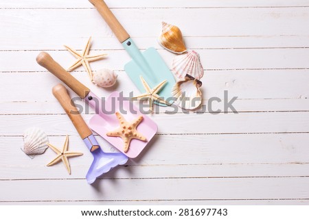 Tools for kids for playing in sand and sea object on white  painted wooden background. Place for text. Vacation  background.