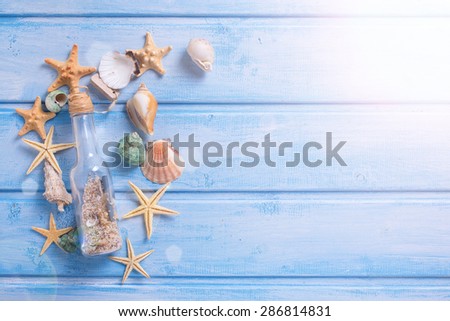 Different marine items  in ray of light on  blue painted wooden background. Sea objects on wooden planks. Selective focus. Place for text.