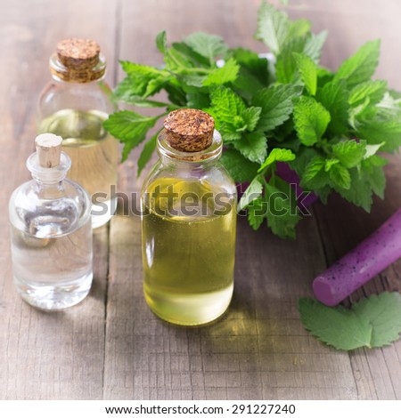 Essential aroma oil with mint on wooden background. Selective focus. Square image.