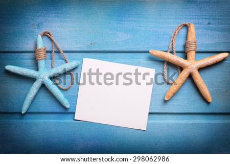 Marine items and empty tag on blue wooden background. Sea objects on wooden planks. Selective focus. Place for text. Toned image.