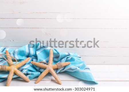 Marine items  and blue towel in ray of light   on white wooden background.  Selective focus. Place for text.