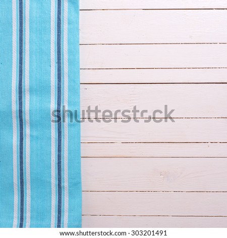 Blue kitchen towel  on white wooden background. Selective focus. Place for text. Square image.