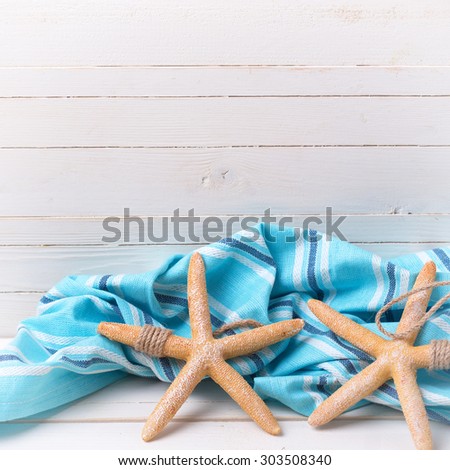 Marine items  and blue towel  on white wooden background.  Selective focus. Place for text. Square image.