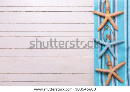 Marine items on blue towel on white wooden background. Sea objects on wooden planks. Selective focus. Place for text.