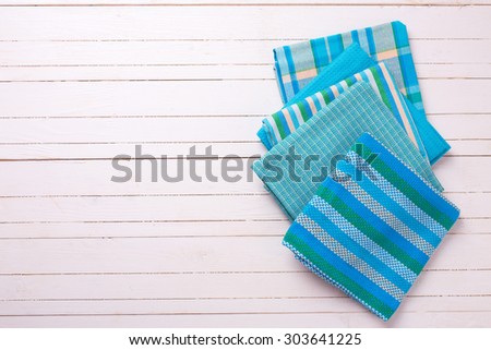 Kitchen towels in blue colors  on white wooden background. Selective focus. Place for text.