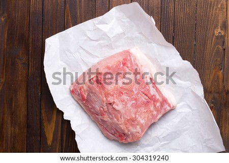Fresh raw meat on paper on dark table. Selective focus. Food and drink.