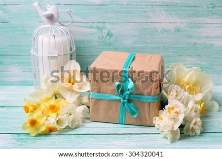 Festive present box and flowers  on turquoise painted wooden background.  Selective focus.