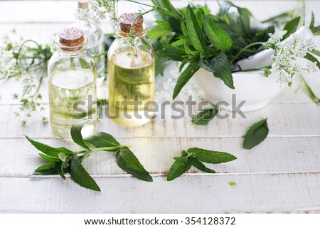 Essential aroma oil with mint  on white painted wooden background. Selective focus. Place for text.