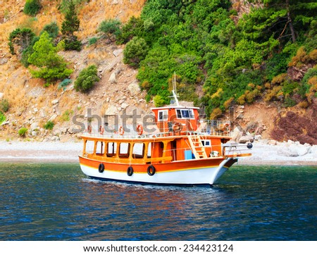 Orange yacht for tourists staying in deserted bay, Turkey