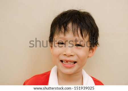young boy smiles and shows his missing teeth