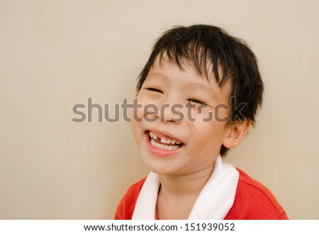 young boy laughs and shows his missing teeth