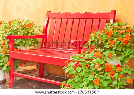 Red classic style armchair setting in garden with flower pot