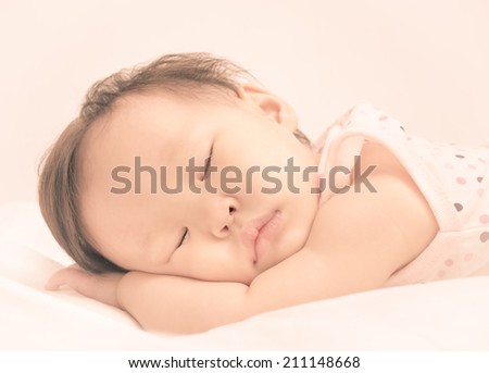 Asian baby girl sleeping on bed with vintage filter
