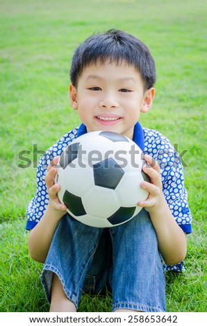 Young Asian boy with his ball in the park