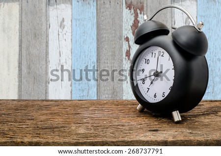 Clock on wood table over old wood wall