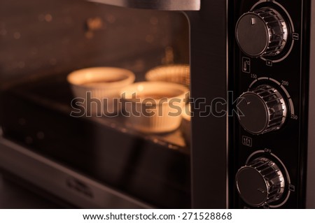 Oven cooking cupcake inside, vintage filter