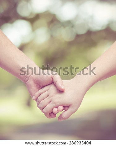Lovers couple holding hands in the garden with vintage filter
