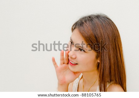young asian girl telling secret on white background