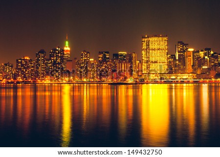 Manhattan skyline by night, reflection on Hudson river. Urban travel concept