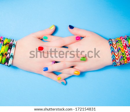 Young girl holding hands in a heart shape, wearing loom bracelets. Close up. Young fashion concept