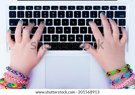 Young girl wearing rubber bracelets using the laptop. Back to school, young fashion, life style concept